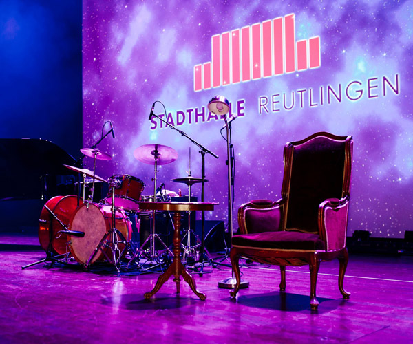 Bühne mit Schlagzeug und Stadthalle Reutlingen-Schriftzug